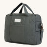 A dark charcoal colour Avery Row changing bag on a cream background.