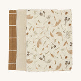 Soft Avery Row muslins set of 3 including a light cream and grassland muslin, a light beige muslin and a brown with white stripe muslin on a cream background.