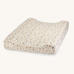 A soft light coloured Avery Row changing cushion mat with a grasslands design on a cream background.
