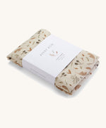 A light cream Avery Row muslin swaddle with a grassland design on a cream background.