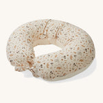 A soft light cream Avery Row nursing pillow with a grassland design on a cream background.