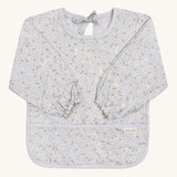 A light blue coloured Avery Row long sleeve bib with a nature design on s cream background.