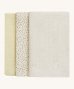 A soft light coloured Avery Row set of three muslin squares including a light with a wild chamomile design muslin, a daisy design and a light green muslin on a cream background.