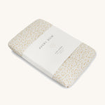 A Avery row muslin swaddle with a daisy flower design on a cream background.