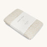 A Avery row muslin swaddle with a daisy flower design on a cream background.