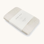 A Avery row muslin swaddle with a wild chamomile design on a cream background.