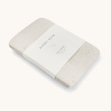 A Avery row muslin swaddle with a wild chamomile design on a cream background.