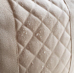 A close up of the water resistant quilted fabric on the outer of the Avery Row Baby Changing Bag in a  Natural colour