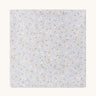 A soft light blue Avery row muslin swaddle with a nature trails design on a cream background