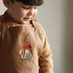 embroidered hedgehog and mushroom pattern of the chest of the apron