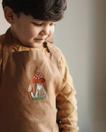 embroidered hedgehog and mushroom pattern of the chest of the apron