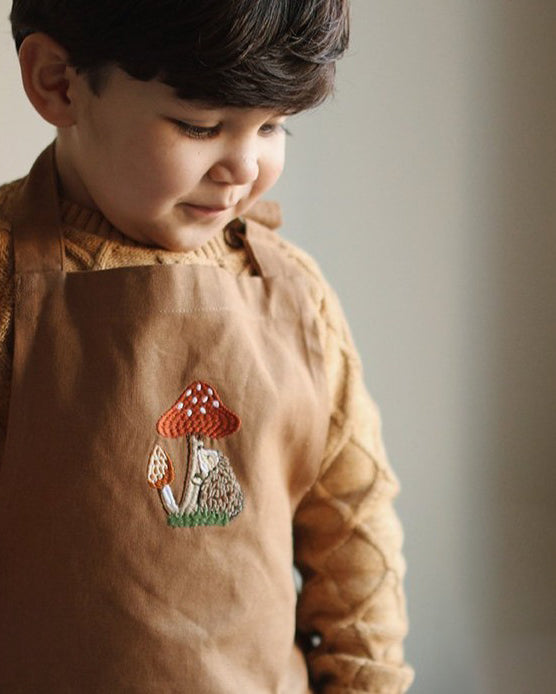 embroidered hedgehog and mushroom pattern of the chest of the apron