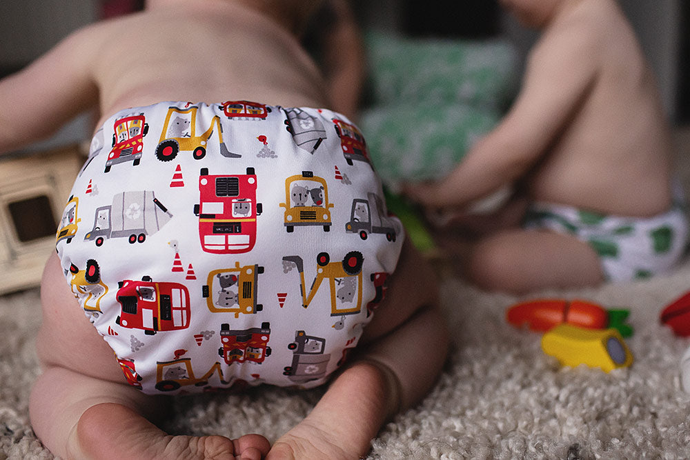 Baba + Boo Transport Nappy worn by baby with toys on the floor