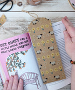 Babipur sheep and daisies and daffodils print kraft eco paper tapes being used to create a DIY bookmark that has been placed in a book. 