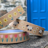 Babipur eco kraft paper tapes with three different Spring design on a wall outdoors. Daffodils, sheep and daisies and pink tulips.