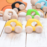 A Bajo handmade wooden yellow mini car next to a beetle car available at Babipur. Photo is in a playroom setting with Grimms blocks in the background and other Bajo mini cars in the background.