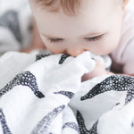 A child grasping the XL Starfish muslin cloth 