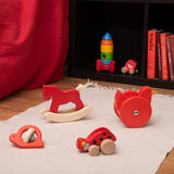 Red coloured wooden Bajo toys placed on a white rug. These heirloom quality toys by Bajo are part of a wide range of wooden toys available here at Babipur.