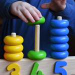 A close up of a child playing with a Bajo 1-5 pull along stacking toy