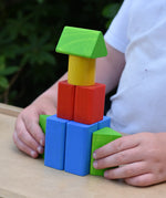 Child playing with the blocks from the Bajo 10 piece sorting board. 