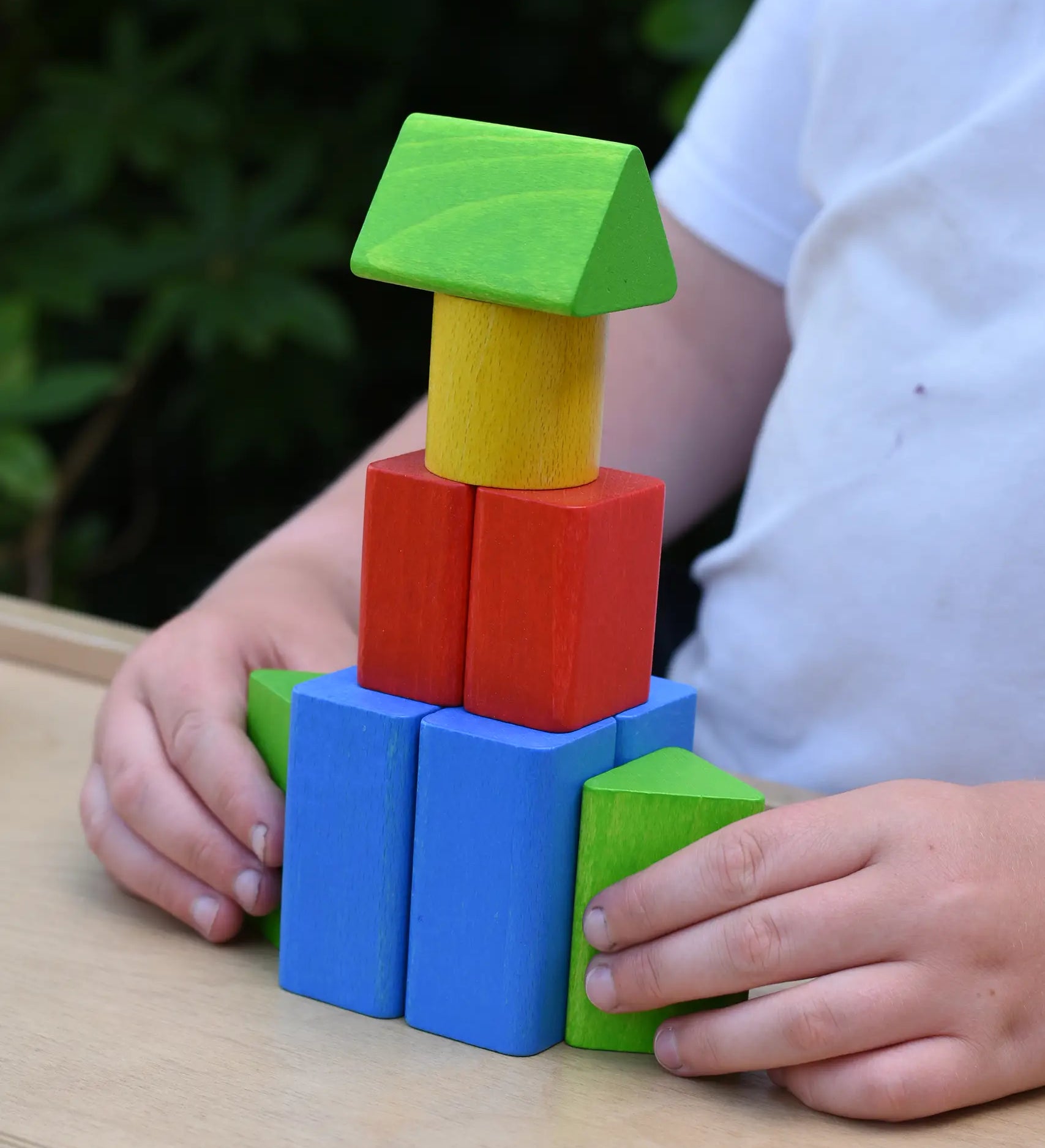 Child playing with the blocks from the Bajo 10 piece sorting board. 