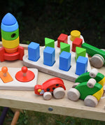 Bajo 10 piece sorting board placed on a Miri slide surrounded by other Bajo wooden toys.