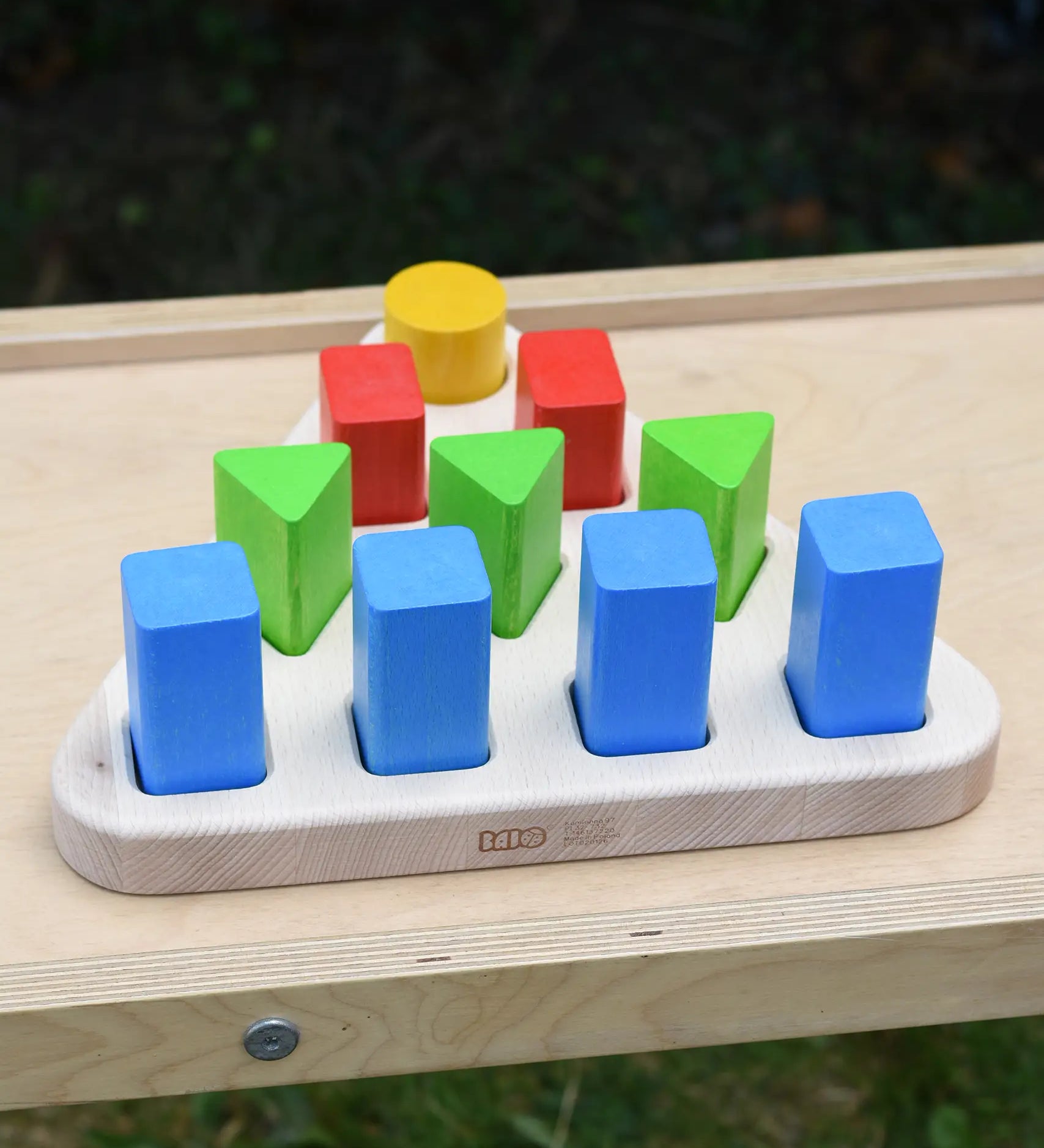 Bajo 10 piece sorting board. Wooden triangle base with 10 slots, 4 square, 3 triangle, 2 rectangle and 1 circle with 10 blocks to fit inside. 