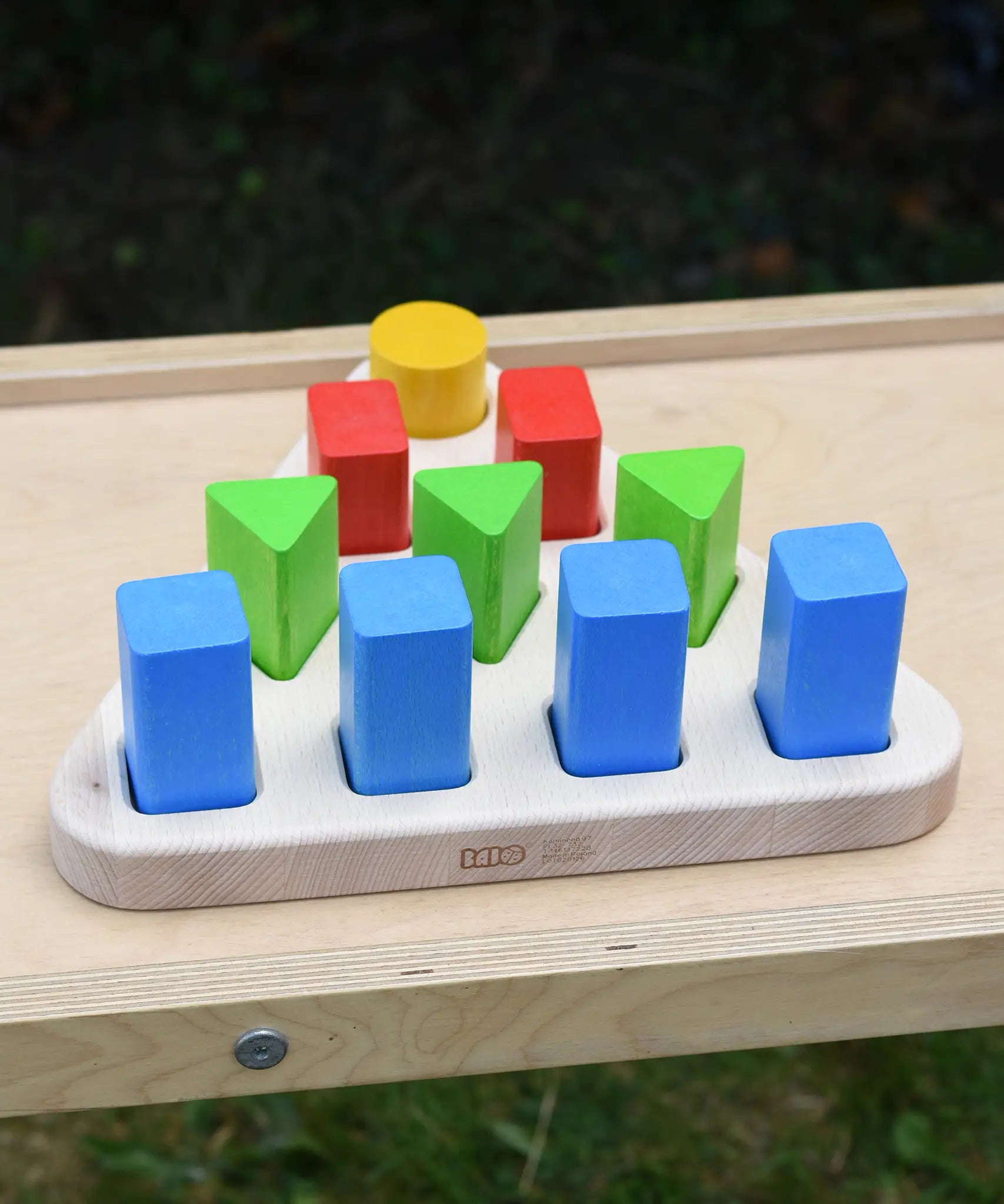 Bajo 10 piece sorting board. Wooden triangle base with 10 slots, 4 square, 3 triangle, 2 rectangle and 1 circle with 10 blocks to fit inside. 
