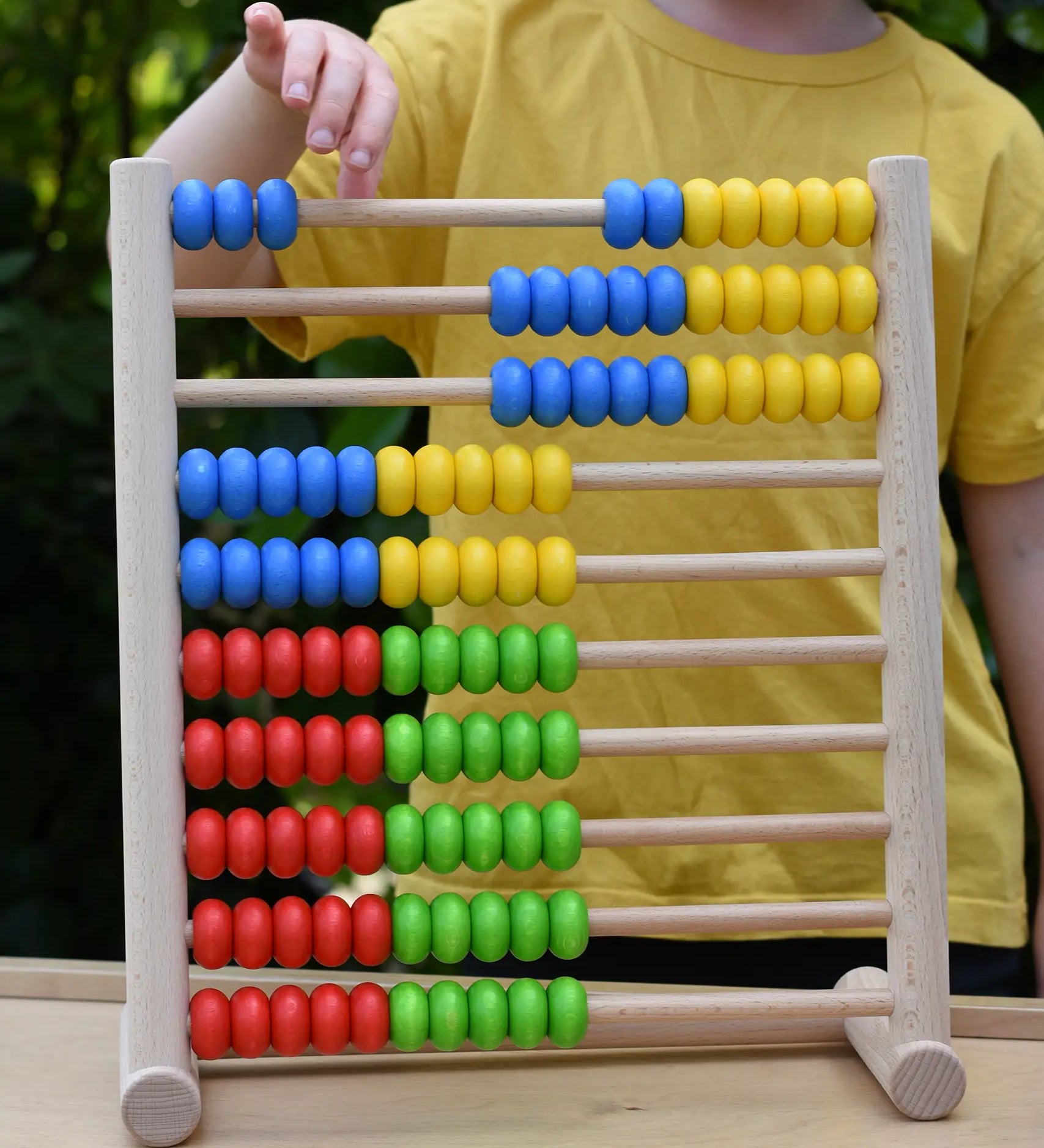 Child playing with the Bajo 100 Bead Abacus counting toy, moving blue coloured counter along the top bar. 