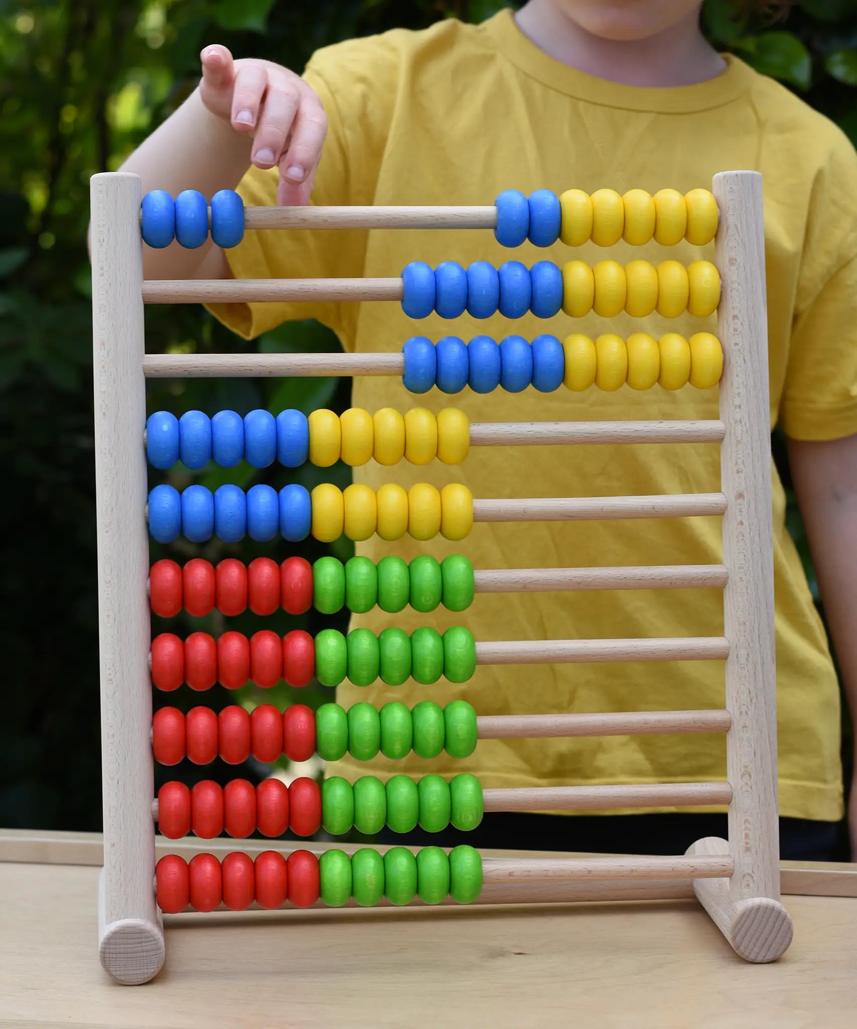 Child playing with the Bajo 100 Bead Abacus counting toy, moving blue coloured counter along the top bar. 