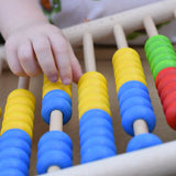 Close up of a child's hand playing with the Bajo 100 Bead Abacus counting toy. 