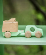 Bajo mint green 4x4 car and horse trailer wooden toy placed on a shelf.