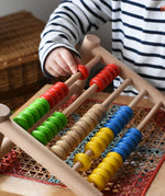 Close up of a child playing with the Bajo 50 bead wide abacus in the Babipur playroom.