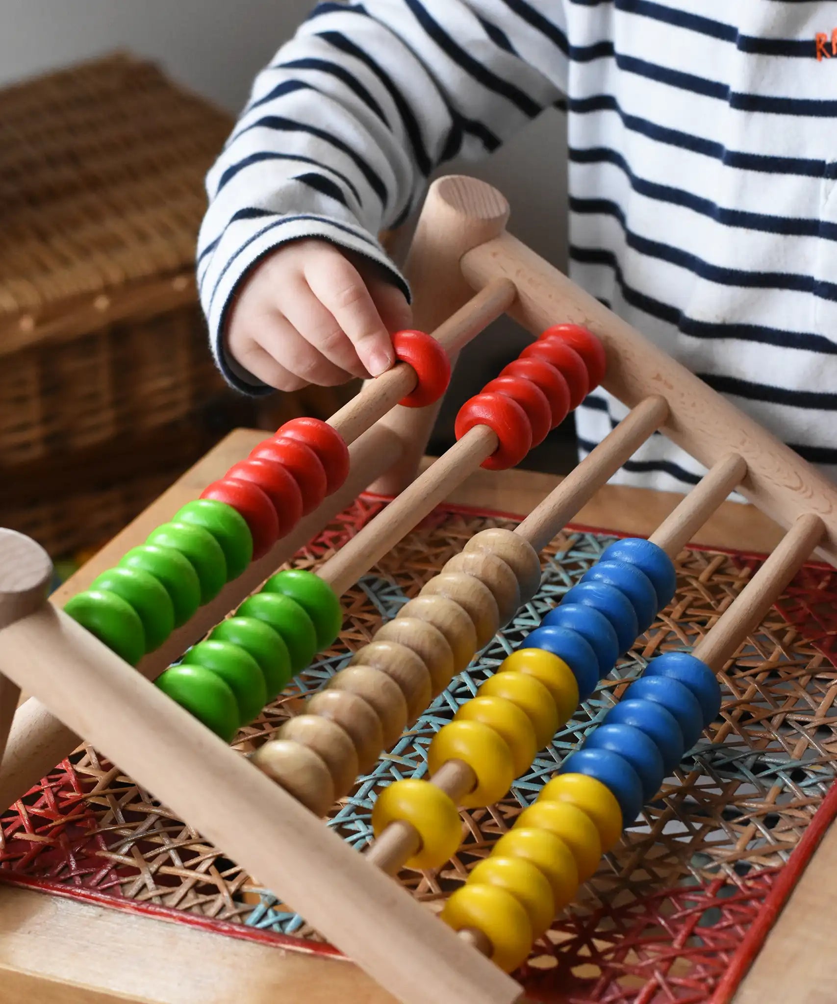 Close up of a child playing with the Bajo 50 bead wide abacus in the Babipur playroom.