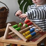 Child playing with the Bajo 50 bead wide abacus in the Babipur playroom.