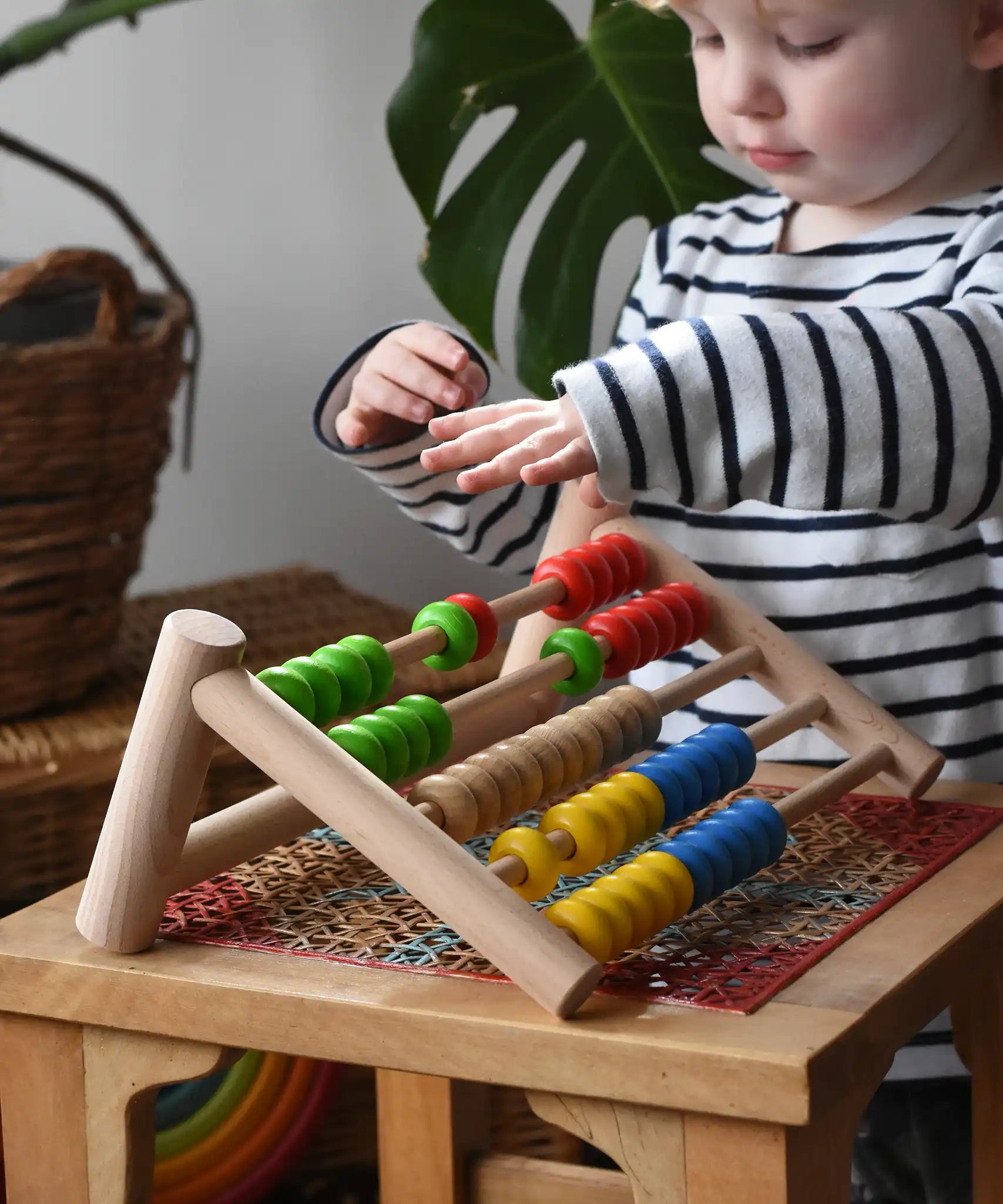 Child playing with the Bajo 50 bead wide abacus in the Babipur playroom.