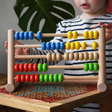 Child playing with the Bajo 50 bead wide abacus in the Babipur playroom.