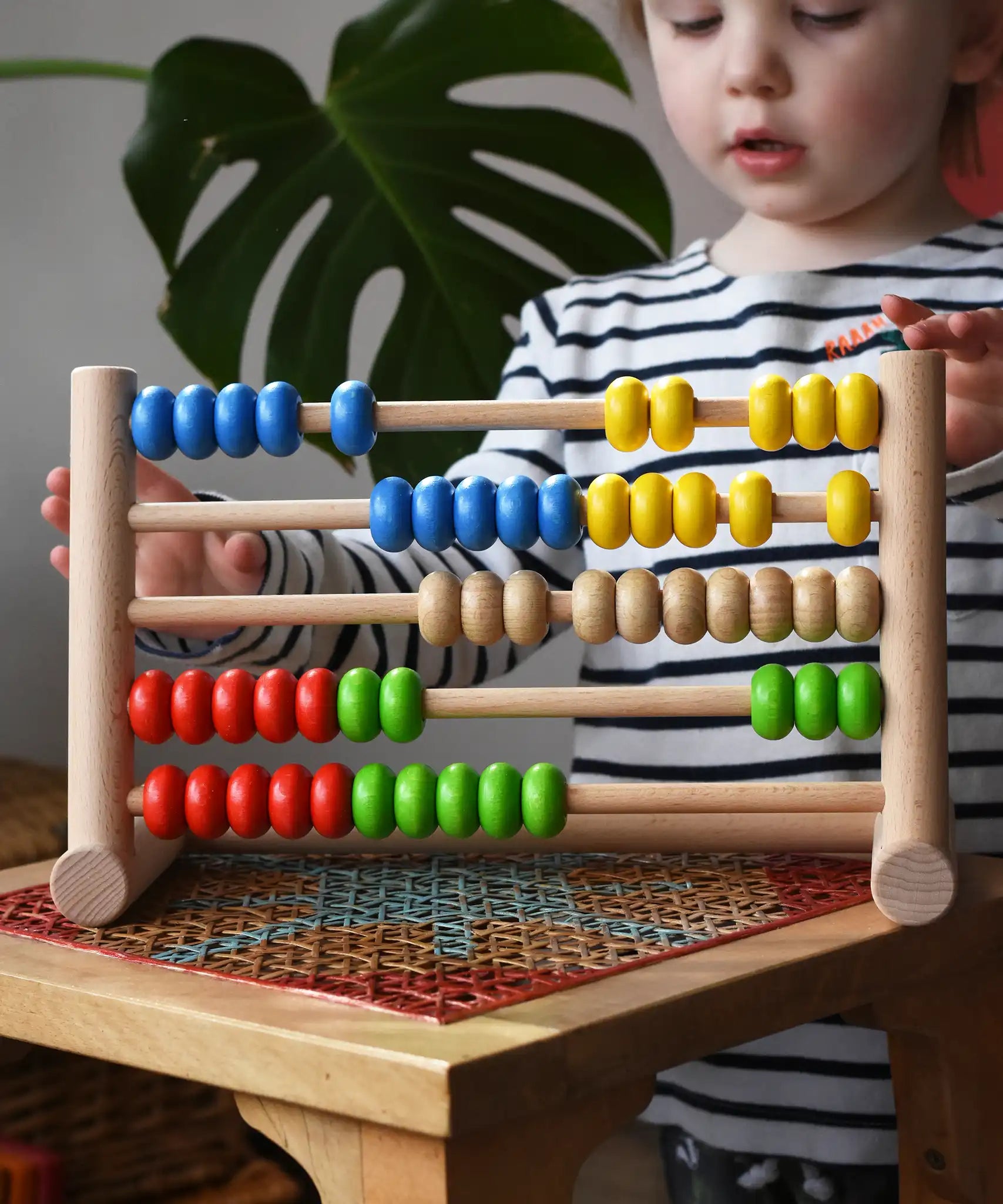 Child playing with the Bajo 50 bead wide abacus in the Babipur playroom.