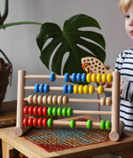 Child playing with the Bajo 50 bead wide abacus in the Babipur playroom.