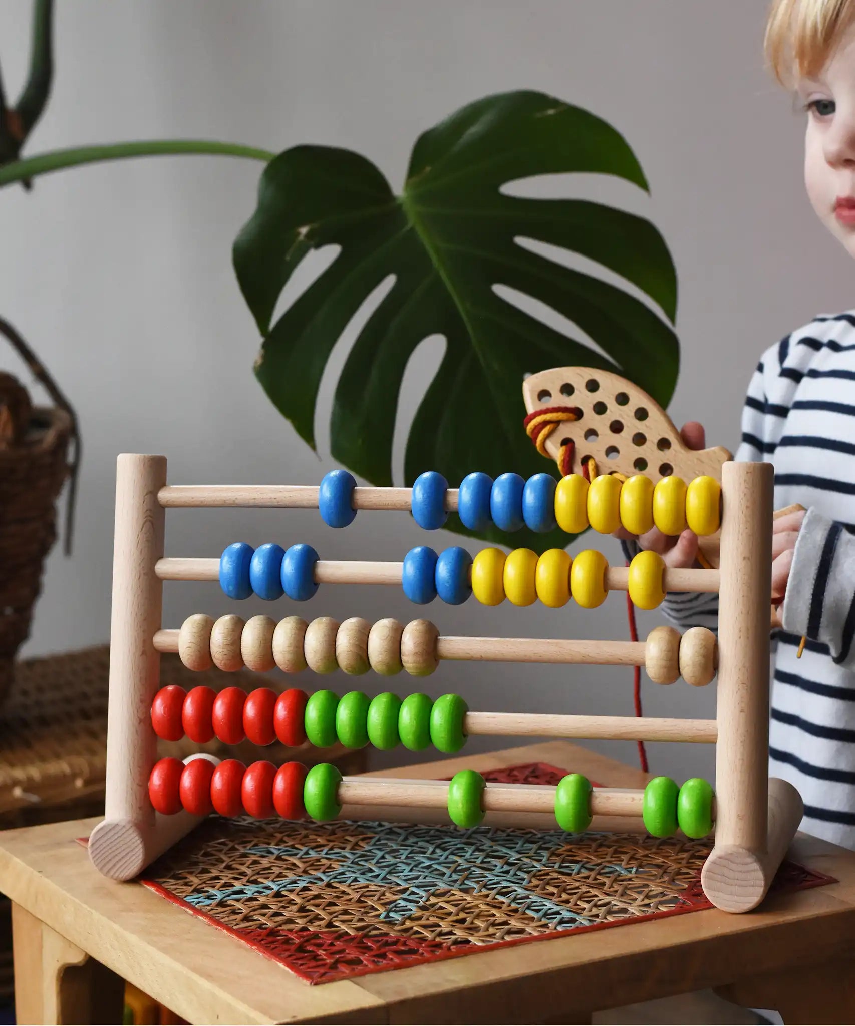 Child playing with the Bajo 50 bead wide abacus in the Babipur playroom.