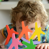 A child peering through the stacked figures from the Bajo Acrobats balancing game. A set of 8 coloured wooden acrobat shaped figures. These heirloom quality toys by Bajo are part of a wide range of wooden toys available here at Babipur.