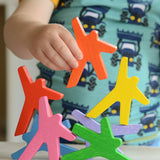 A close up of a child's hand playing with the Bajo Acrobats balancing game. A set of 8 coloured wooden acrobat shaped figures. These heirloom quality toys by Bajo are part of a wide range of wooden toys available here at Babipur.