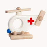 Bajo Ambulance Helicopter wooden toy. A white painted helicopter with a red cross and natural wooden stands and propellors. These heirloom quality toys by Bajo are part of a wide range of wooden toys available here at Babipur. 