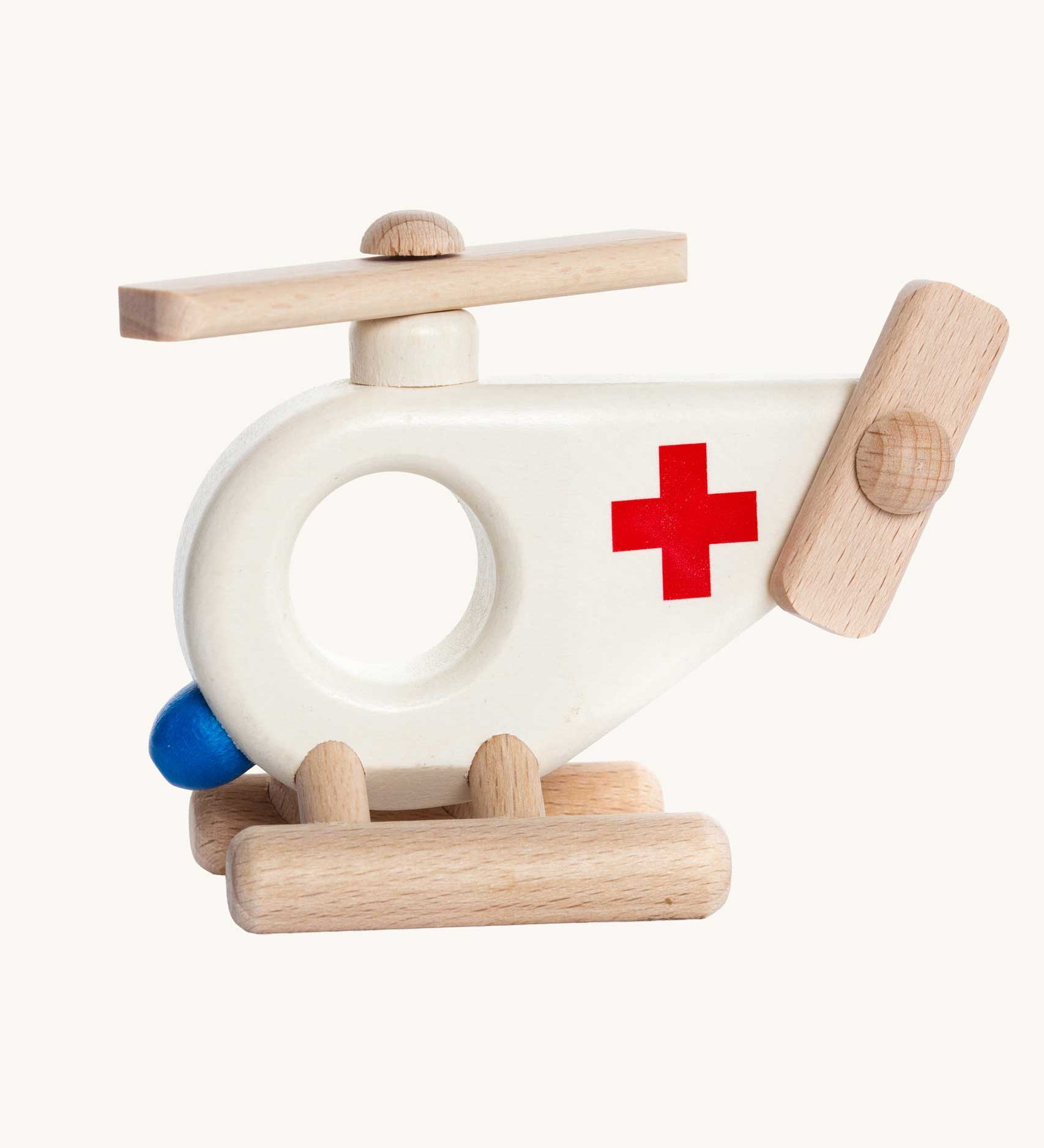 Bajo Ambulance Helicopter wooden toy. A white painted helicopter with a red cross and natural wooden stands and propellors. These heirloom quality toys by Bajo are part of a wide range of wooden toys available here at Babipur. 