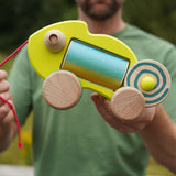 Person holding a colorful wooden chameleon baby toy