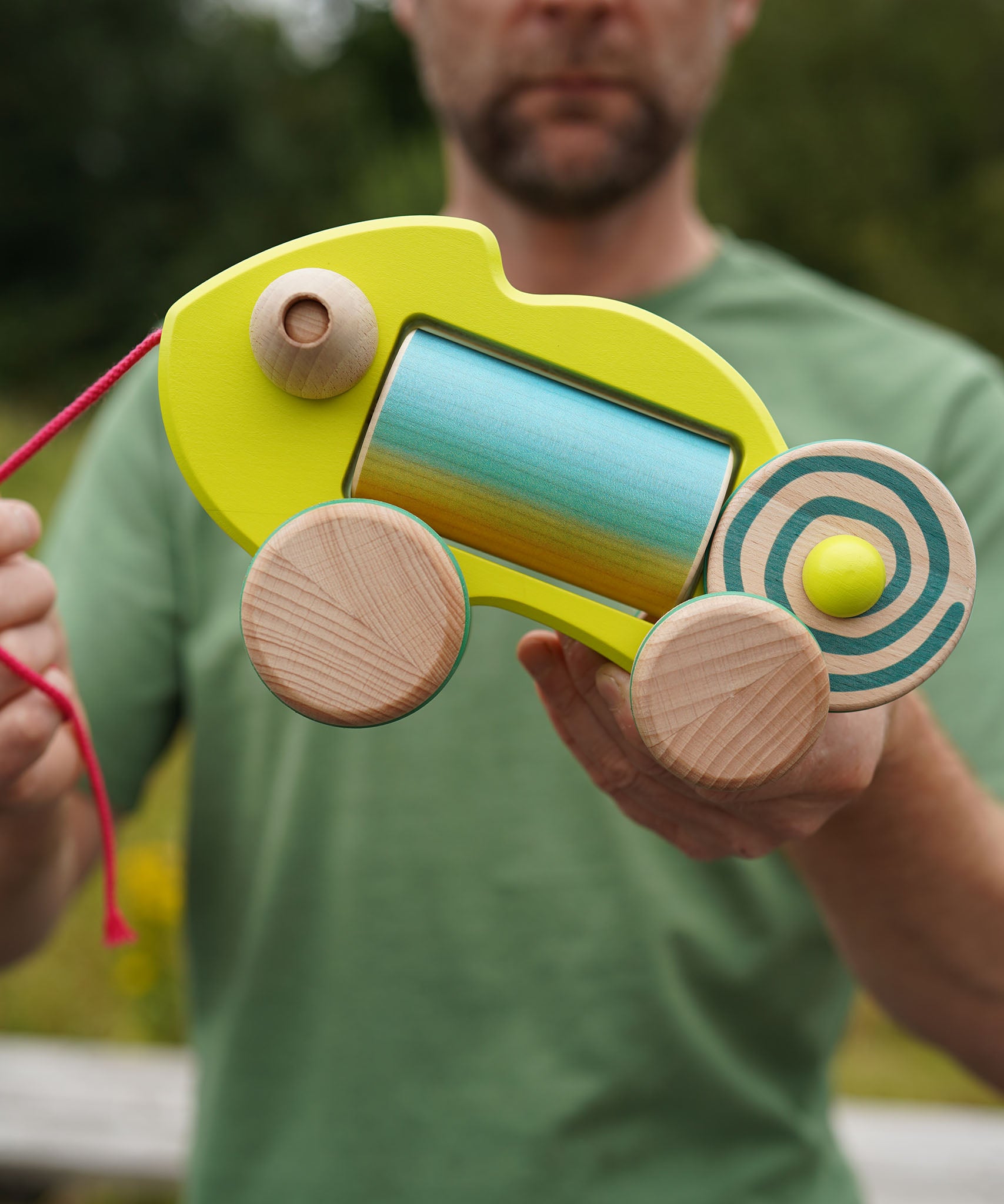 Person holding a colorful wooden chameleon baby toy