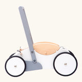 Side profile view of the Bajo wooden monochrome baby walker. Large white wheels with black rubber trims on the edges.
