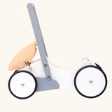 Side profile view of the Bajo wooden monochrome baby walker set up as a dolls pram. The movable hood can also be taken off or placed on the base of the walker.  