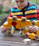 A child playing with the Bajo bee hive blocks.