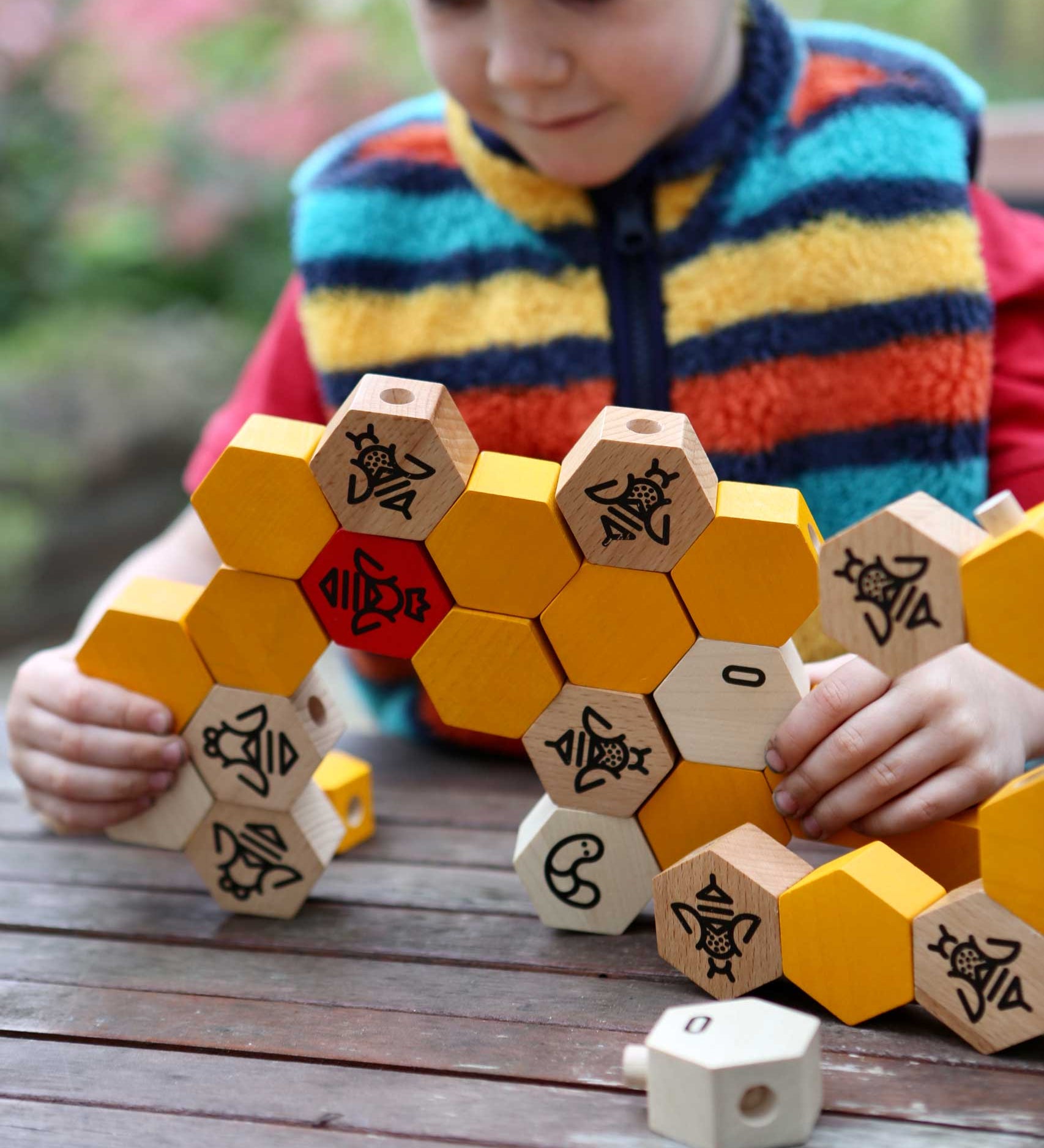 A child playing with the Bajo bee hive blocks.